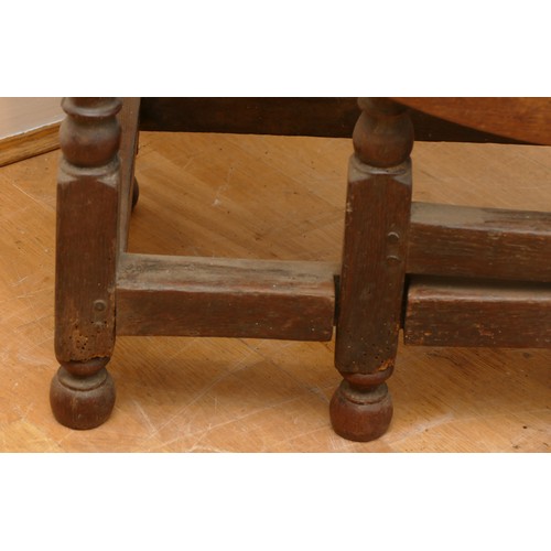 463 - A late 18th century oak gateleg dining table, the extending planked top of oval form, raised on turn... 