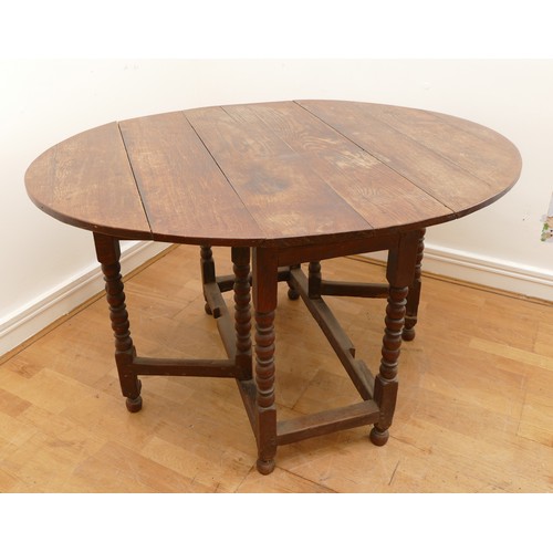 463 - A late 18th century oak gateleg dining table, the extending planked top of oval form, raised on turn... 