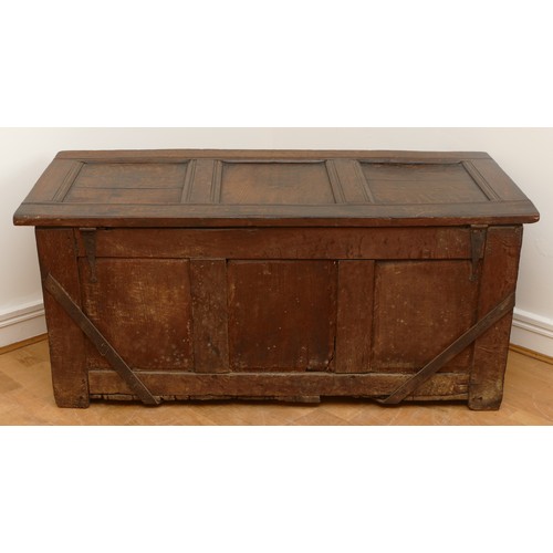 476 - A 17th century oak coffer, the hinged three panel top, above a guilloche frieze and two lozenge carv... 