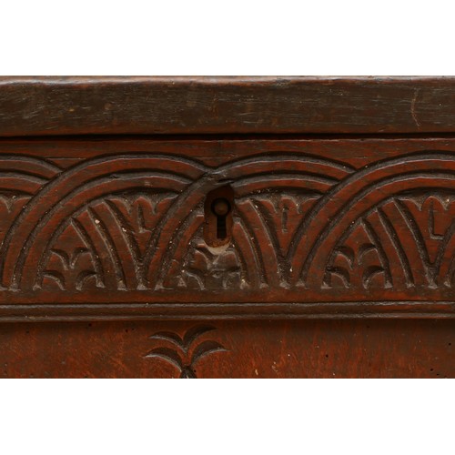 476 - A 17th century oak coffer, the hinged three panel top, above a guilloche frieze and two lozenge carv... 