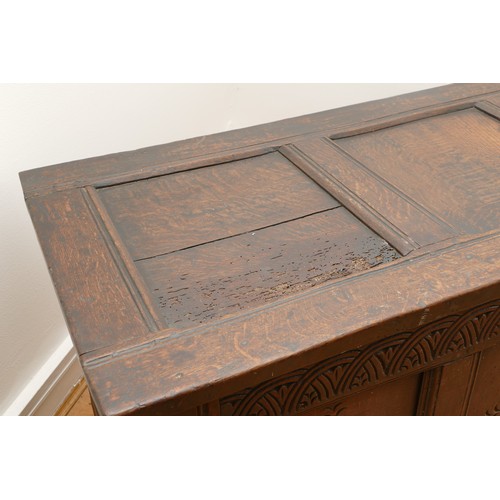 476 - A 17th century oak coffer, the hinged three panel top, above a guilloche frieze and two lozenge carv... 