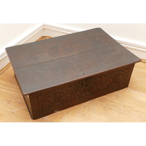 477 - A 17th century oak bible box, with iron mounts and lock, the front panel carved with foliate and lun... 