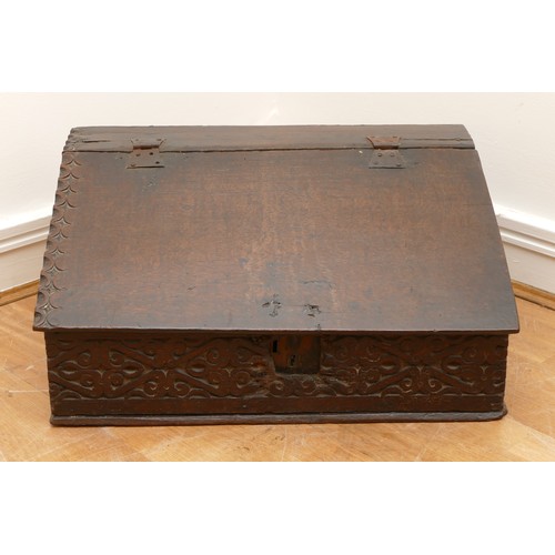 478 - A late 17th century oak bible box, the carved hinged top above carved foliate sides, with iron lock ... 