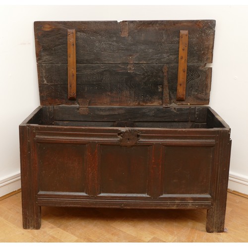 482 - An 18th century oak coffer, having two plank hinged top over three panel front, with arcaded frieze ... 