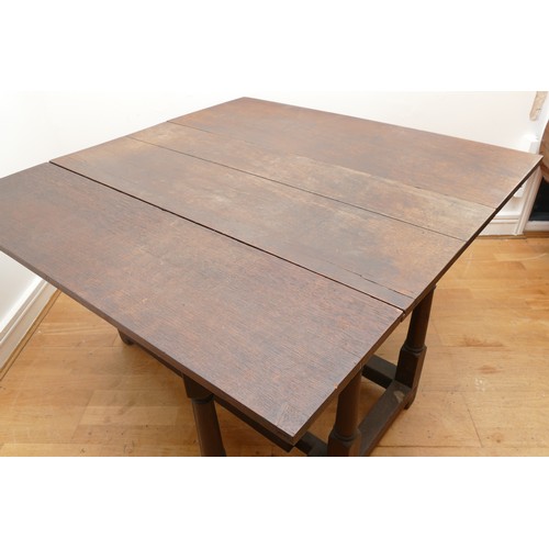 485 - A 19th century oak drop leaf gateleg action dining table, raised on square supports, united by perip... 