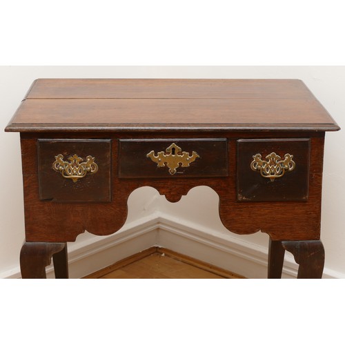 491 - A George III oak lowboy, having three frieze drawers and shaped apron, raised on cabriole legs with ... 