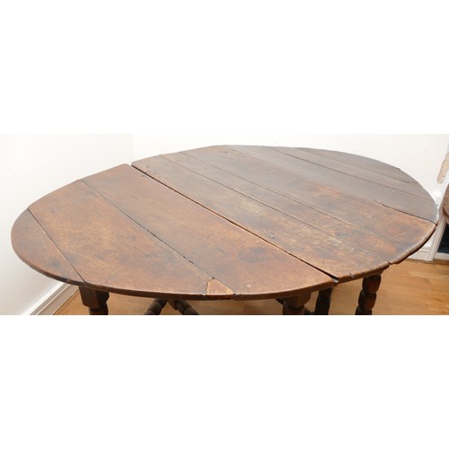 494 - A 17th century oak drop leaf dining table, the oval top raised on turned supports with double gate-l... 