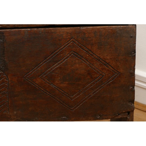 503 - A 17th century oak bible box, the sloped top with incised concentric roundels to the top above carve... 