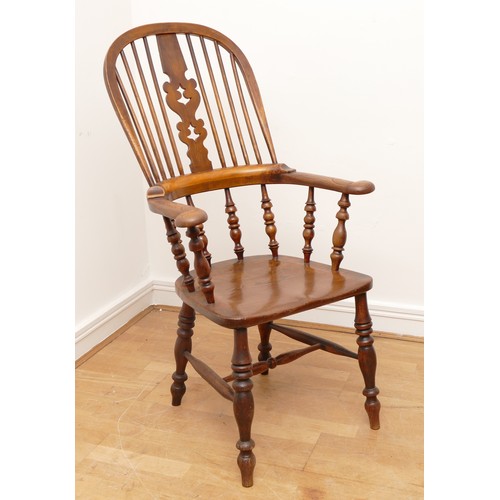 504 - A 19th century oak and elm armchair, with arcaded and pierced crest rail over a stick back and sides... 