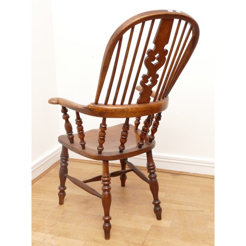 504 - A 19th century oak and elm armchair, with arcaded and pierced crest rail over a stick back and sides... 