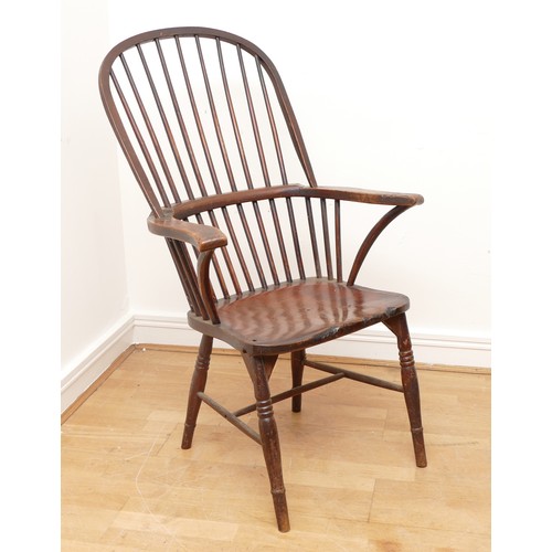 505 - A late 19th century pine windsor armchair, having spindle back and sides with scroll arms, saddle se... 