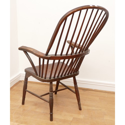 505 - A late 19th century pine windsor armchair, having spindle back and sides with scroll arms, saddle se... 