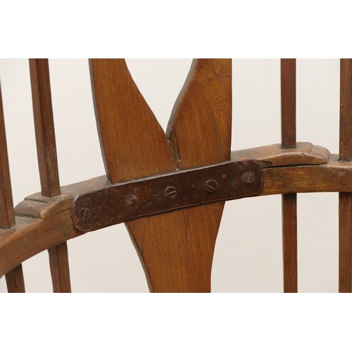 509 - An 18th Century primitive West Country Windsor elbow chair, the arch back with central shaped splat ... 