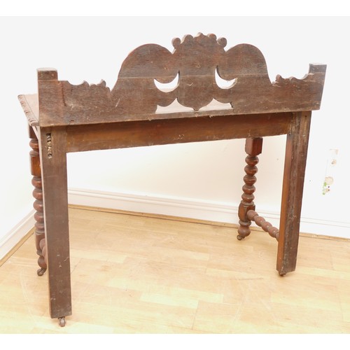 517 - A Victorian carved oak side table with scroll back rail over turned legs, 113 x 45 x 110cm.