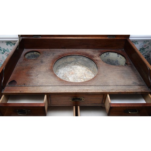 214 - A 19th century mahogany campaign washstand, the hinged lid opening to reveal a tin lined wash bowl, ... 