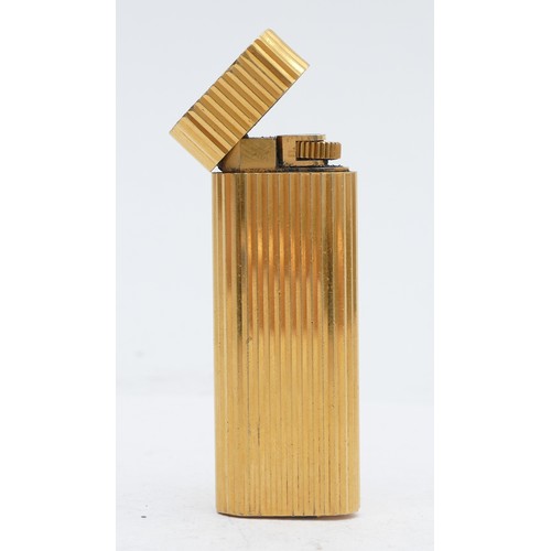 92 - Cartier, a gold plated rollagas lighter, serial number 92812G, lacking flap to open the gas compartm... 