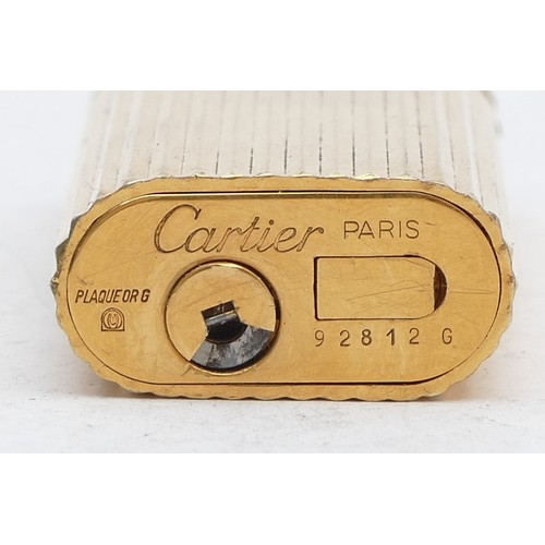 92 - Cartier, a gold plated rollagas lighter, serial number 92812G, lacking flap to open the gas compartm... 