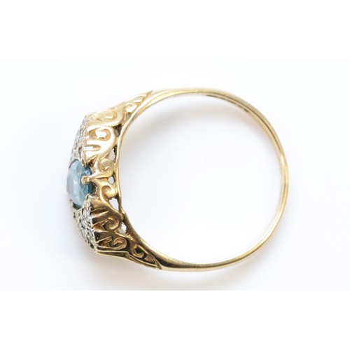 554 - A 9ct gold blue topaz and diamond dress ring with scroll patterned gallery, P, 3.1g