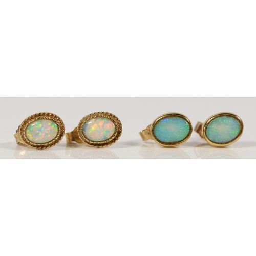 620 - A pair of 9ct gold opal earrings with scroll backs, together with a similar synthetic opal pair, 3g