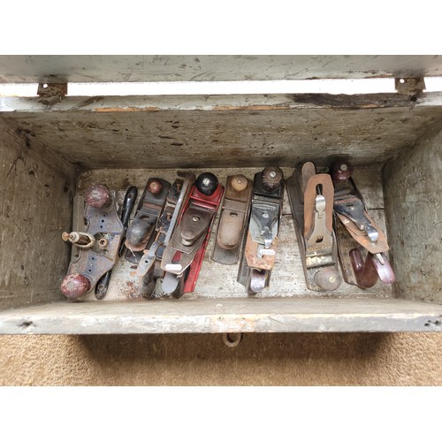 22 - A wooden toolbox containing a collection of hand planes.