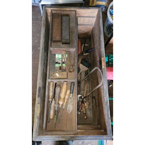 46 - A large wooden toolbox containing a collection of carpenters hand tools.