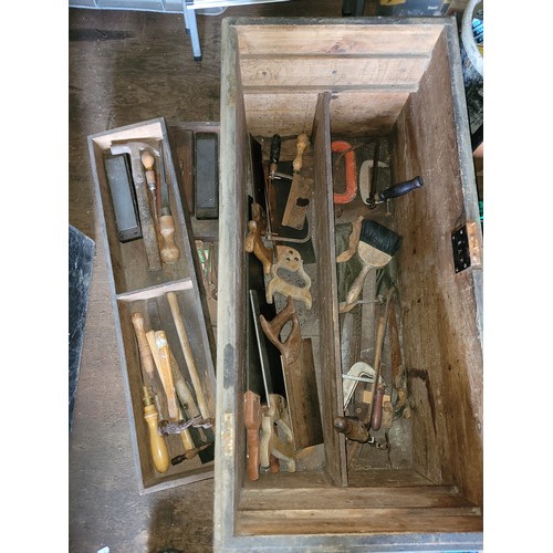 46 - A large wooden toolbox containing a collection of carpenters hand tools.