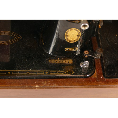 111 - An early 20th century manual Singer sewing machine, model 99K, with instruction manual and fitted tr... 