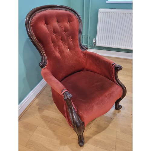 581 - A Victorian carved mahogany armchair with scroll arm terminals, the spoon back and sprung seat uphol... 