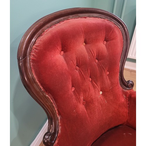 581 - A Victorian carved mahogany armchair with scroll arm terminals, the spoon back and sprung seat uphol... 