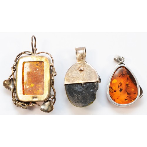 1145 - A large silver and amber floral pendant, stone 45 x 30mm and two other silver mounted amber pendants... 