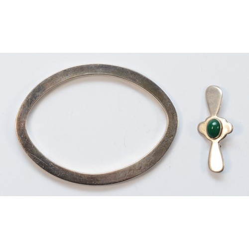 1151 - A Mexican silver oval bangle, internal 78 x 54mm and a Mexican silver and green stone brooch, 31gm