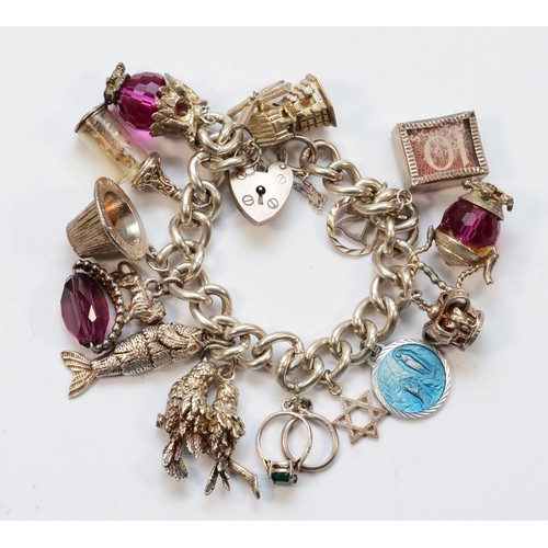 1182 - A silver charm bracelet, including a 10 shilling note, 105gm