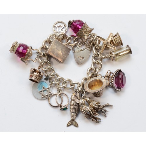 1182 - A silver charm bracelet, including a 10 shilling note, 105gm