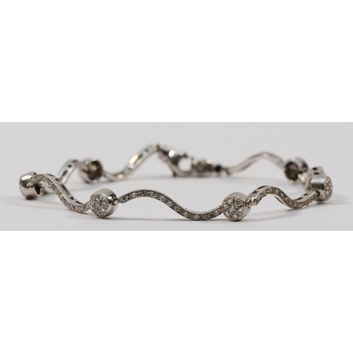 1334 - An Italian 18ct white gold, stamped 750, and brilliant cut diamond wavy link and ball bracelet, appr... 