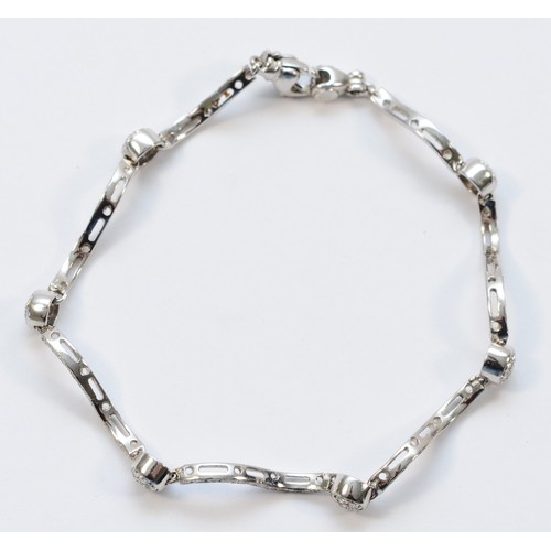 1334 - An Italian 18ct white gold, stamped 750, and brilliant cut diamond wavy link and ball bracelet, appr... 