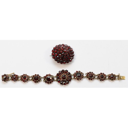 11 - A low grade silver gilt Bohemian garnet cluster bracelet, lacking one link, 15cm and an oval brooch,... 