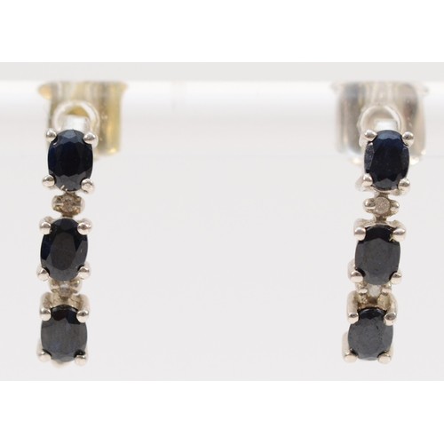 133 - A pair of 9ct gold oval cut sapphire and diamond earrings with scroll backs, 16mm drop, 1.8g