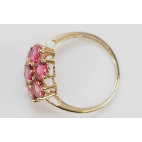 134 - A 9ct gold fushia pink gemstone floral cluster ring, N, 15mm ring front, 2.5g