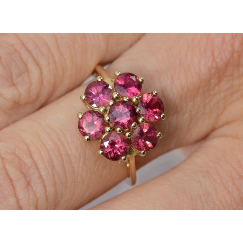 134 - A 9ct gold fushia pink gemstone floral cluster ring, N, 15mm ring front, 2.5g