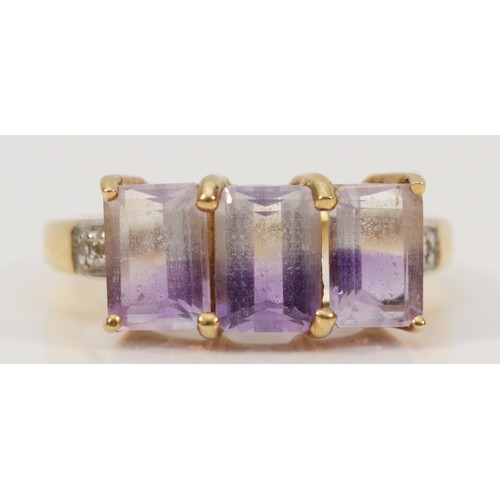 167 - A 9ct gold amethyst three stone cocktail ring with white gemset shoulders, M 1/2, 3.4g