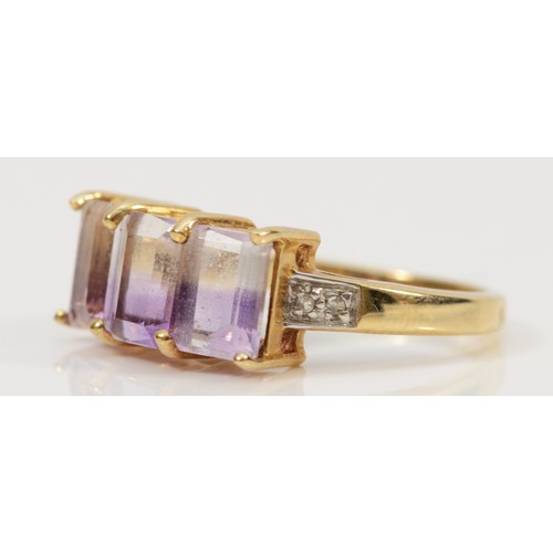 167 - A 9ct gold amethyst three stone cocktail ring with white gemset shoulders, M 1/2, 3.4g