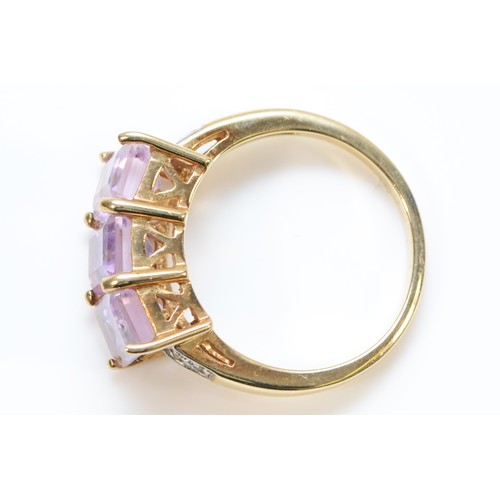 167 - A 9ct gold amethyst three stone cocktail ring with white gemset shoulders, M 1/2, 3.4g