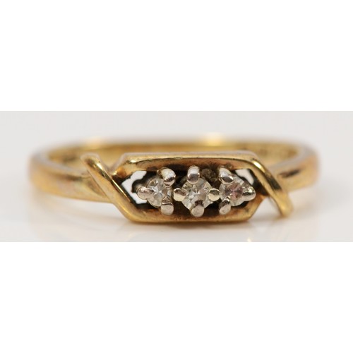 557 - A 9ct gold three diamond ring with cross over detail, J 1/2, 1.9g