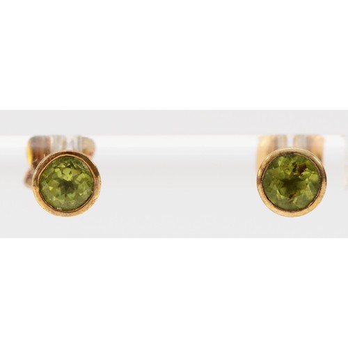 583 - A pair of 9ct gold peridot stud earrings with scroll backs, 5mm diameter, 1.4g