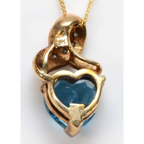 668 - A 9ct gold heart shaped blue topaz and diamond pendant with chain, 15mm total pendant length, 2.6g