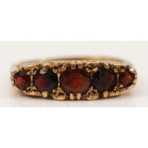 704 - A 9ct gold vintage garnet five stone ring with patterned gallery, Birmingham 1973, M 1/2, 3.6g