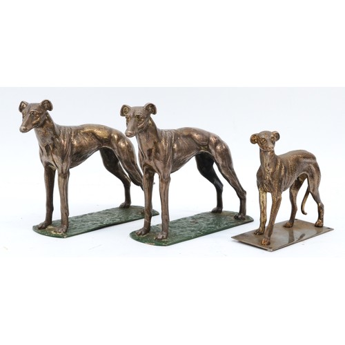 164 - A pair of metal greyhounds on green painted bases, one lacking his tail, height 14cm and another sim... 