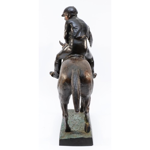 167 - After Mene, a bronze of a racehorse and jockey at a slow trot, raised on cold painted grass base, un... 