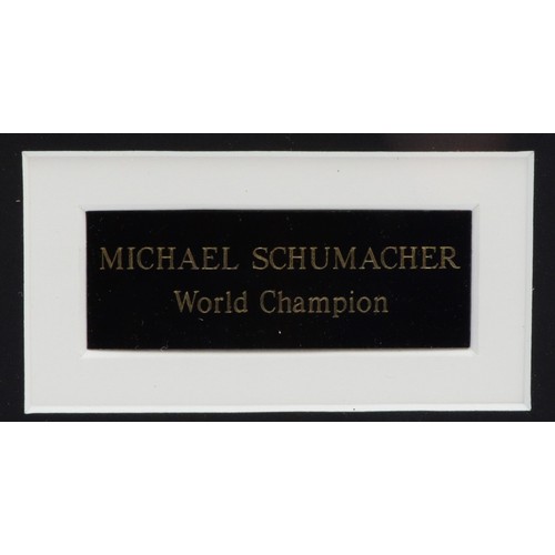 35 - Michael Schumacher, a signed and mounted white Ferrari fabric panel, 61 x 48cm overall. (1 item)