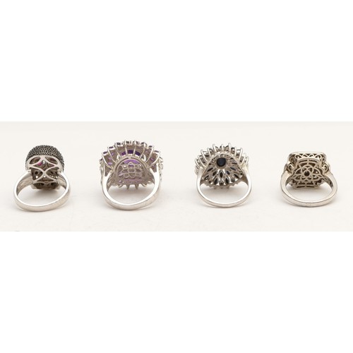 73 - A silver and gemstone set skull ring, M and three other silver gemset rings, 27gm